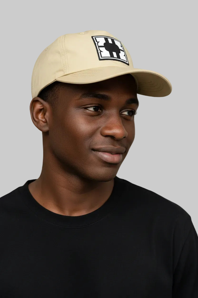 Model wearing a beige cap with a logo on a gray background