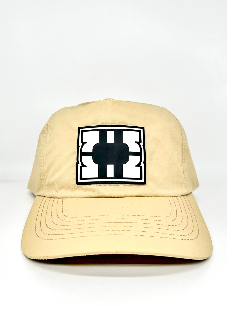 Beige cap with a black and white logo on a white background